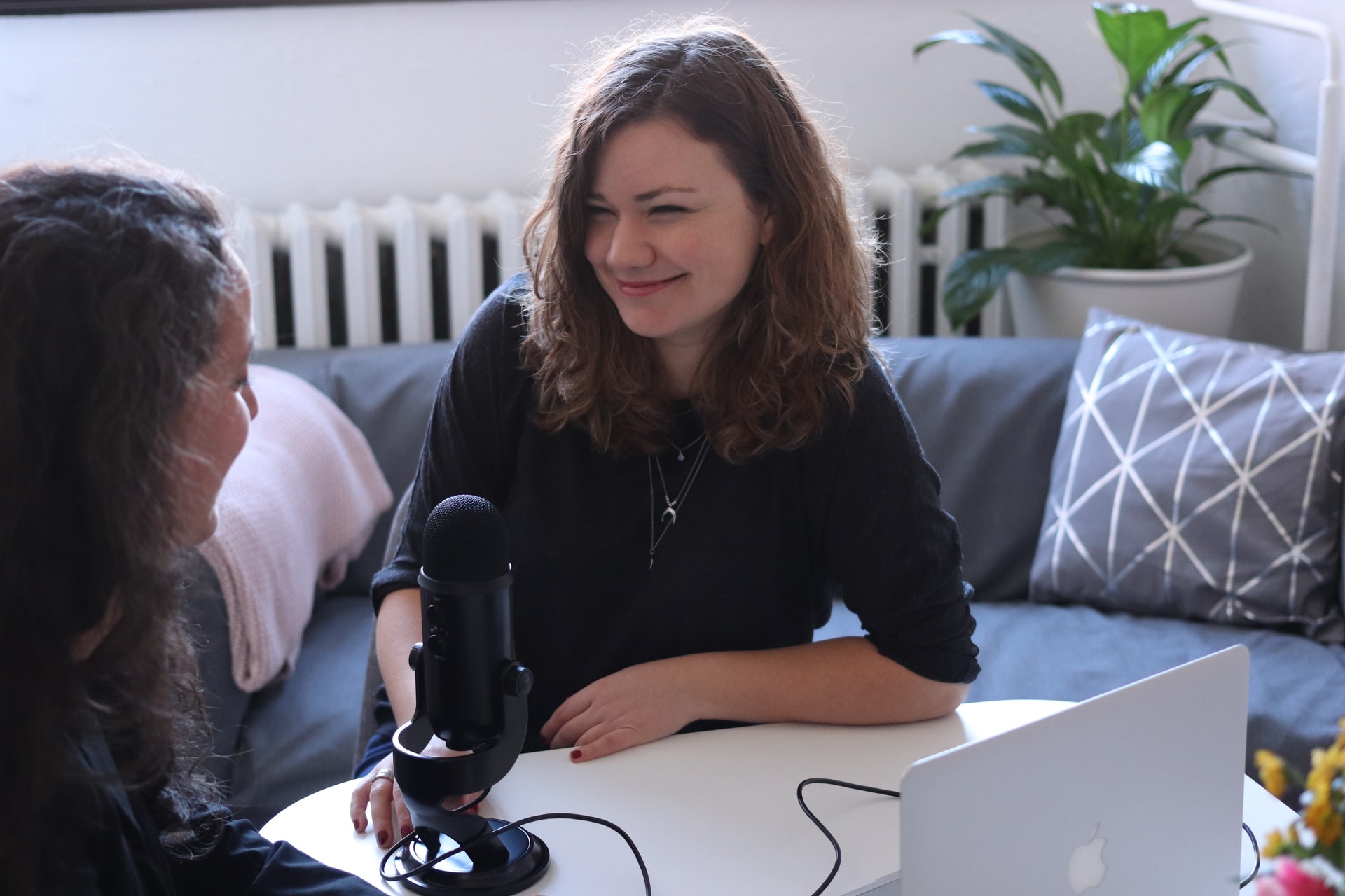 senior reporter, Helen Paquet, woman in black half-sleeved shirt sitting while facing woman and smiling