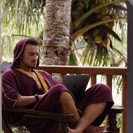 Pete Kaminski wearing Beach Bisht® hoodie bathrobe plum color from beach bisht terry towel beach cover up kimono collections